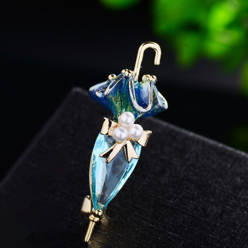 Zenitha Kristall-Regenschirmbrosche – Eleganz mit einem skurrilen Twist