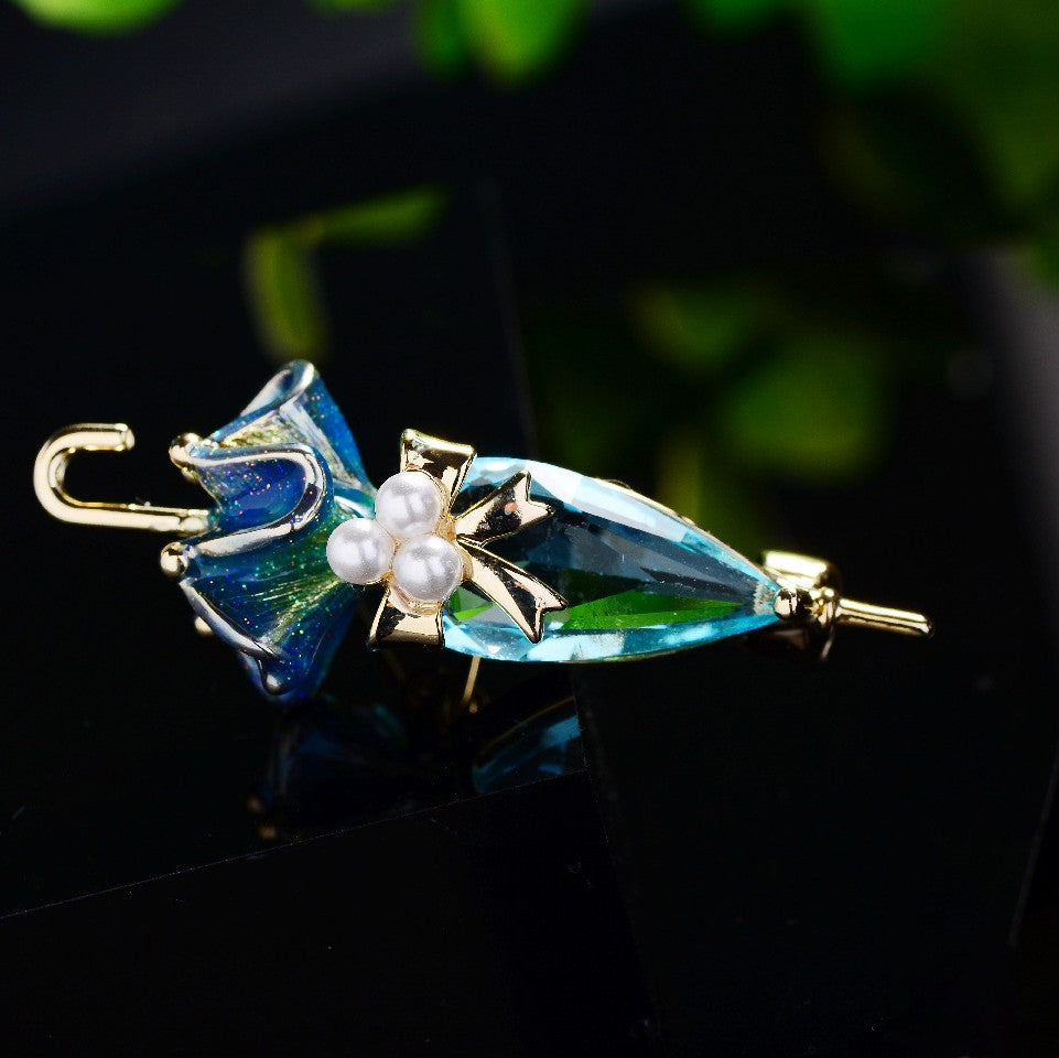 Zenitha Kristall-Regenschirmbrosche – Eleganz mit einem skurrilen Twist
